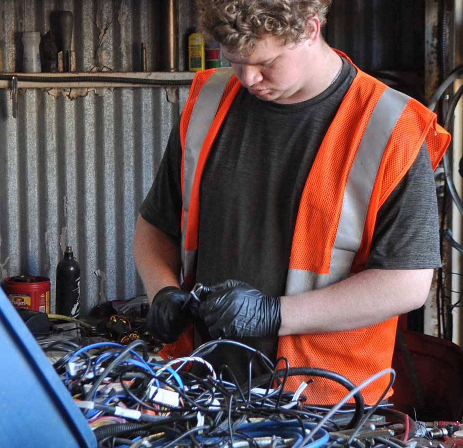 K&K Recycling employee Zac Eckelberger works to remove wire ends