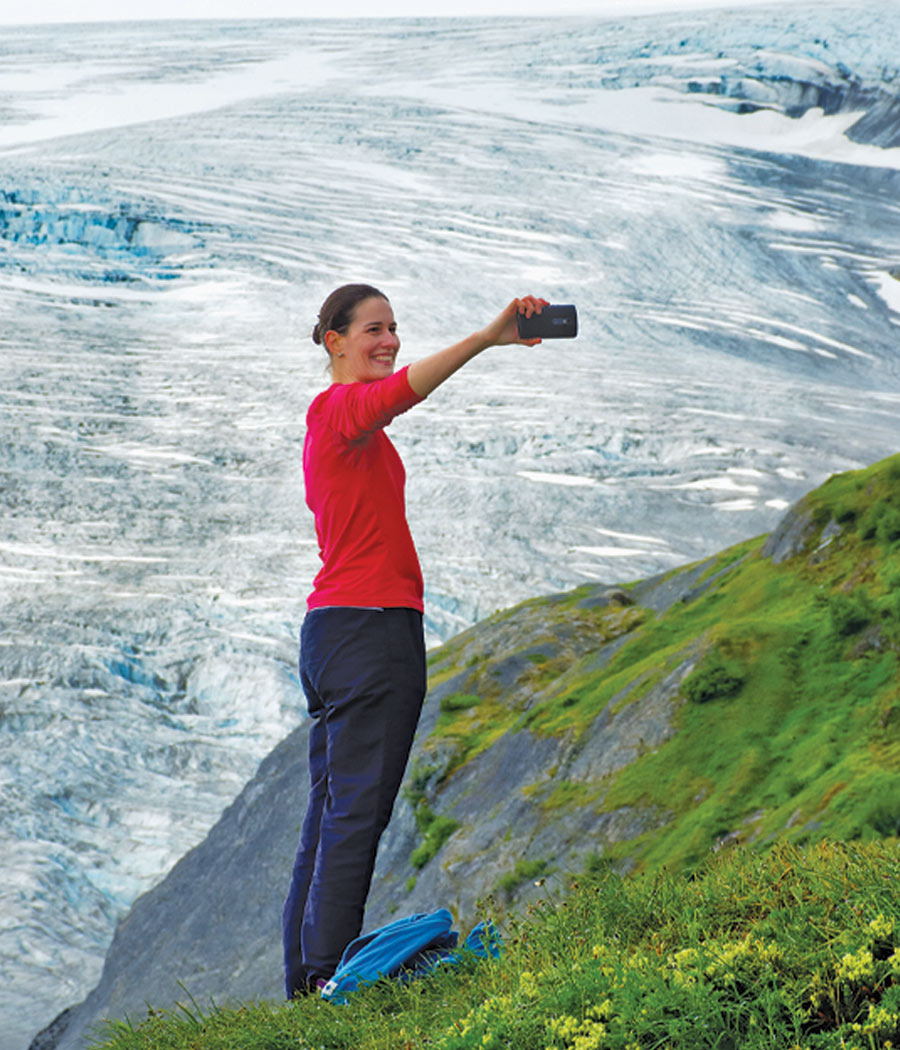 Woman takes a selfie with the Exit Glacier in the background