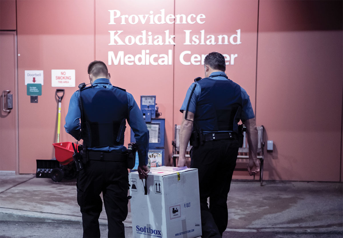 Providence Kodiak Island Medical Center security department caregivers deliver a box of COVID-19 vaccine to the facility on Tuesday
