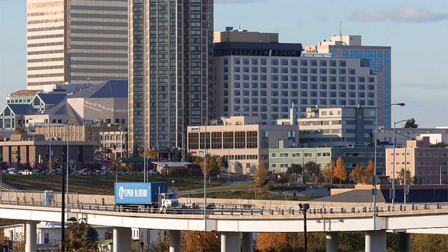 Span Alaska truck on highway with skyline in the background