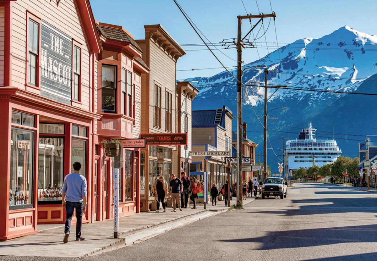view down street in Skagway, with snow covered mountains in the distance