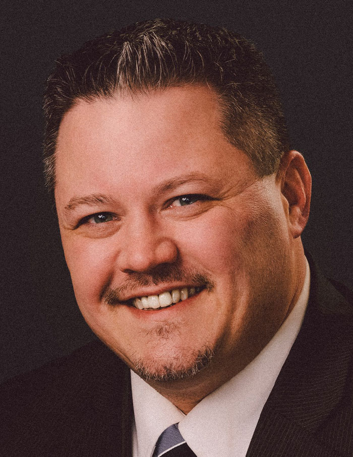 Askren in a suit and smiliing