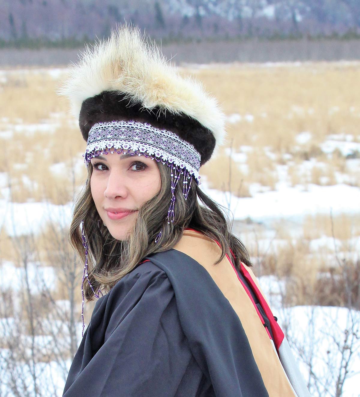 Kinka Vincze sitting outside in her graduation garb and smiling