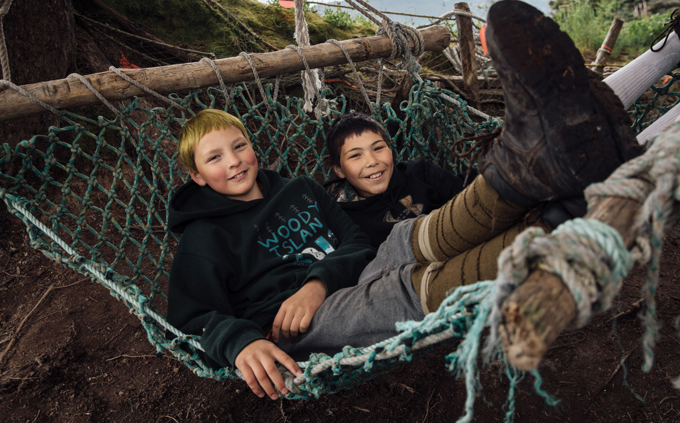 Two kids laying on a hammock