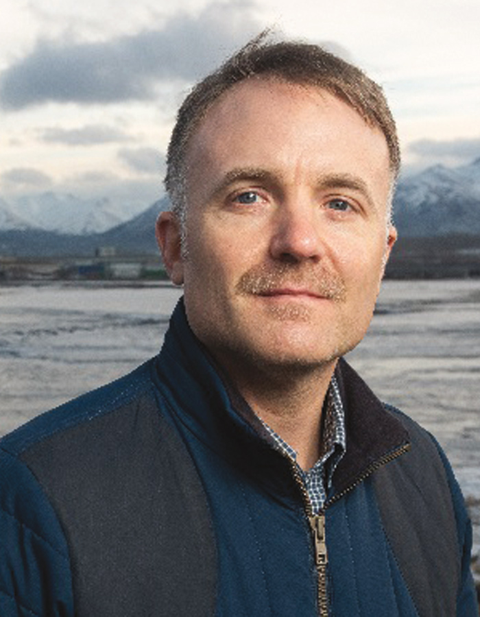 A headshot image of Alex Hofeling grinning (President at TOTE Maritime Alaska)