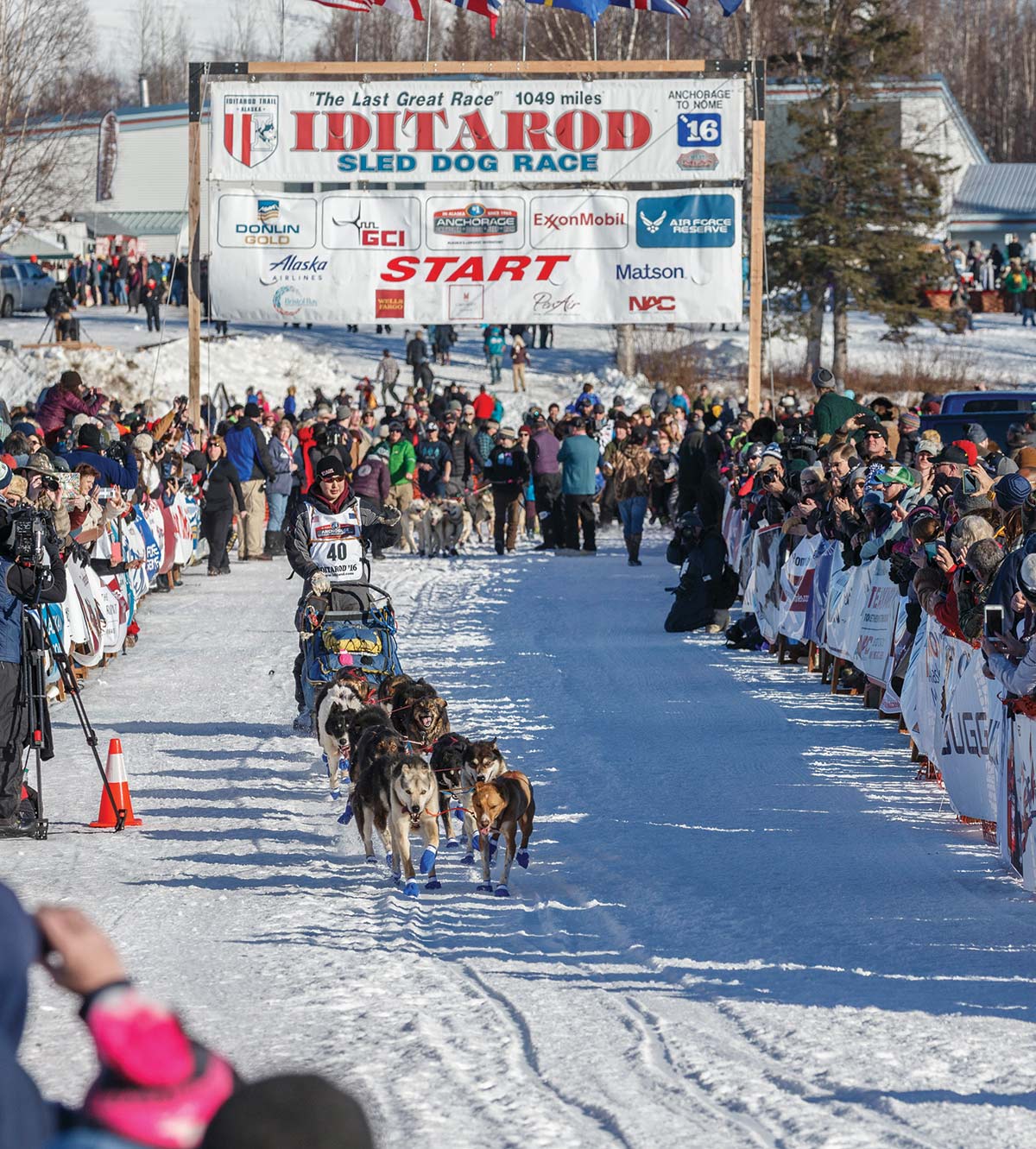 crowd clapping and cheering on Mike Williams Jr. as he leaves the start during the Ceremonial Start of the 2016 Iditarod in Willow, Alaska