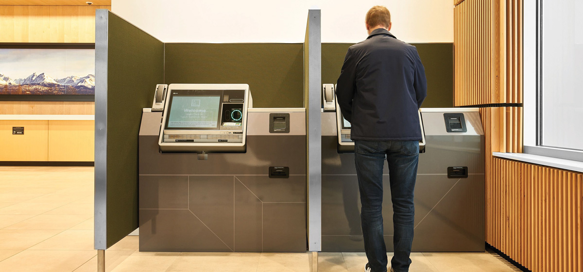 man using an ATM machine inside the bank