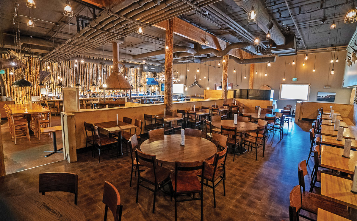 The interior of 49th State Brewing – Denali Park is designed to feel like the outdoors with driftwood and birch motifs, yak skulls, and a color scheme that replicates the changing seasons.