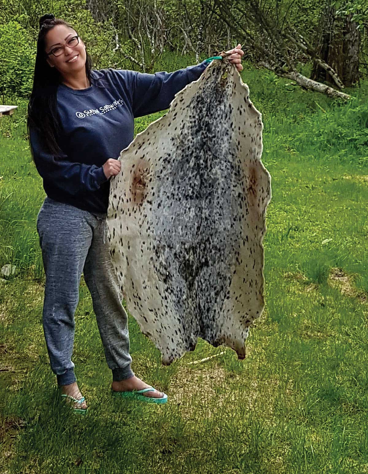 Alaska Natives holding up a fur