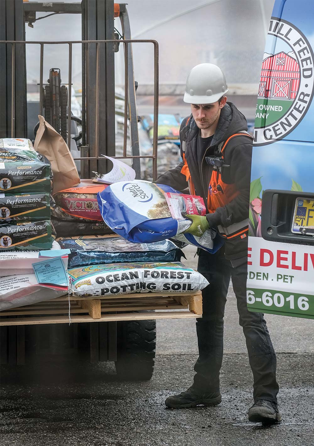 Alaska Mill & Feed employee unloading bags from van