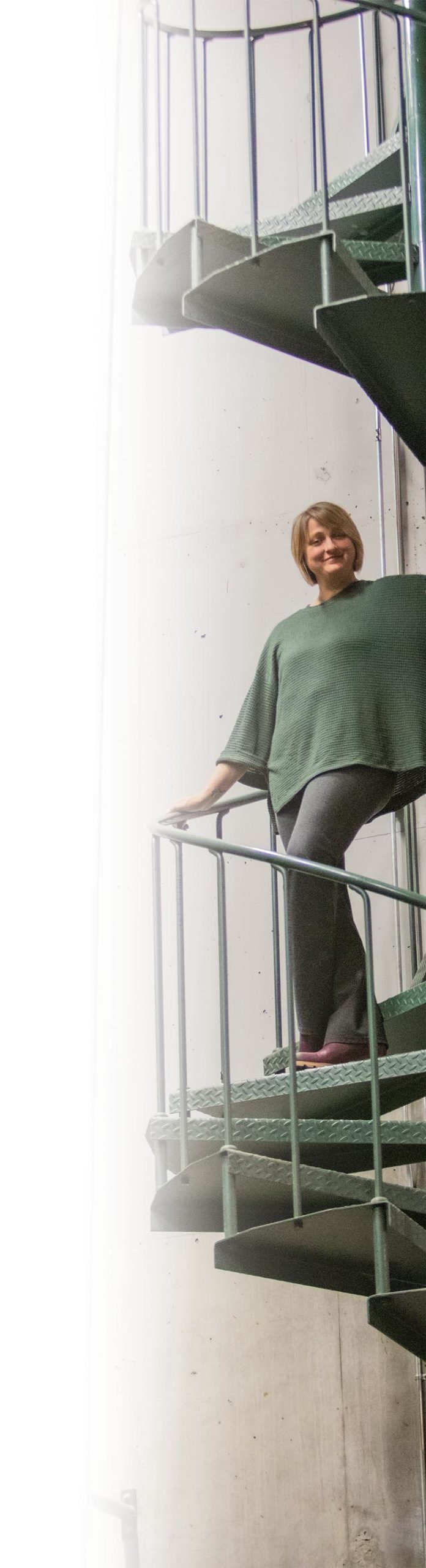 Codie Costello standing on tall spiral stairwell