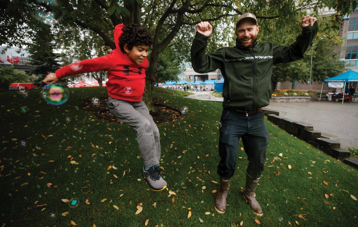 man and kid jumping, surrounded by bubbles