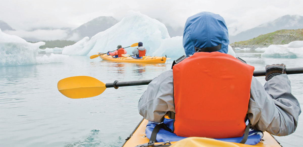 People kayaking through glaciers