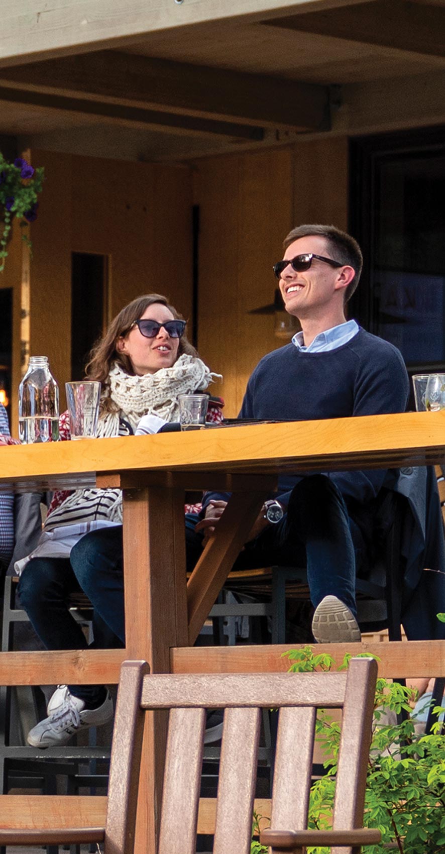 a man and woman enjoy outdoor seating at a restaurant
