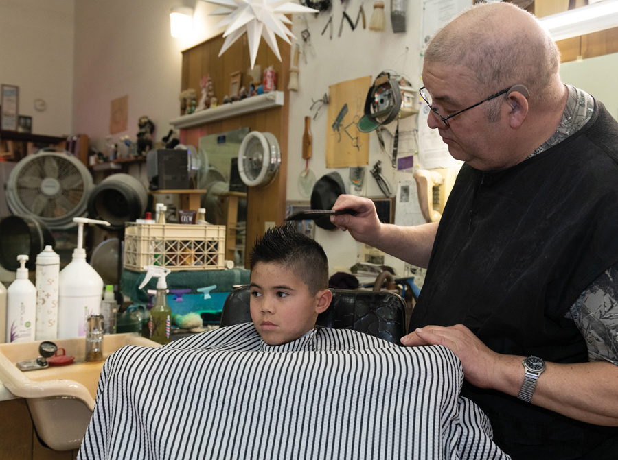 Stan using a comb during a little boy's haircut