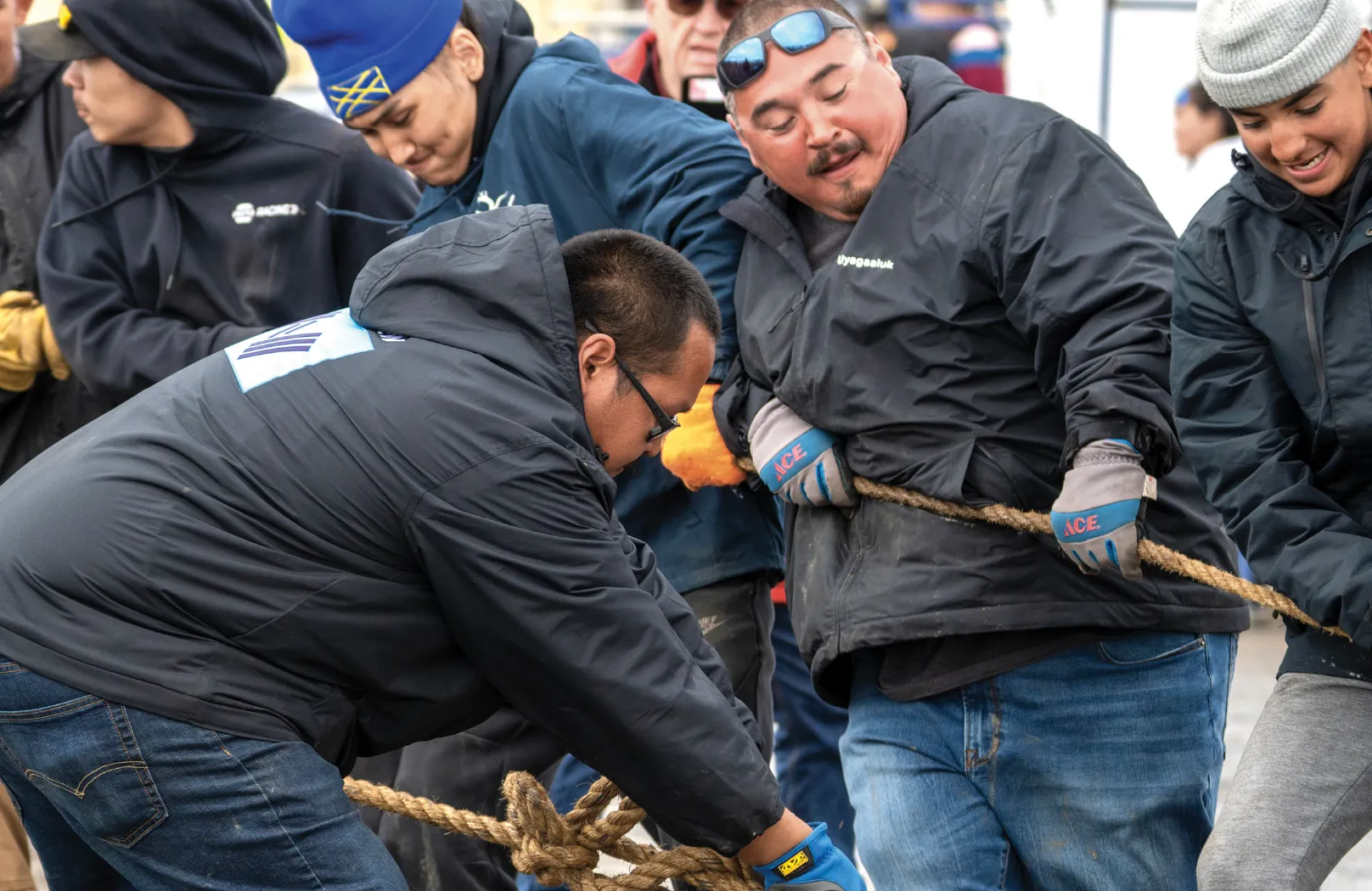 Group of men pulling rope together