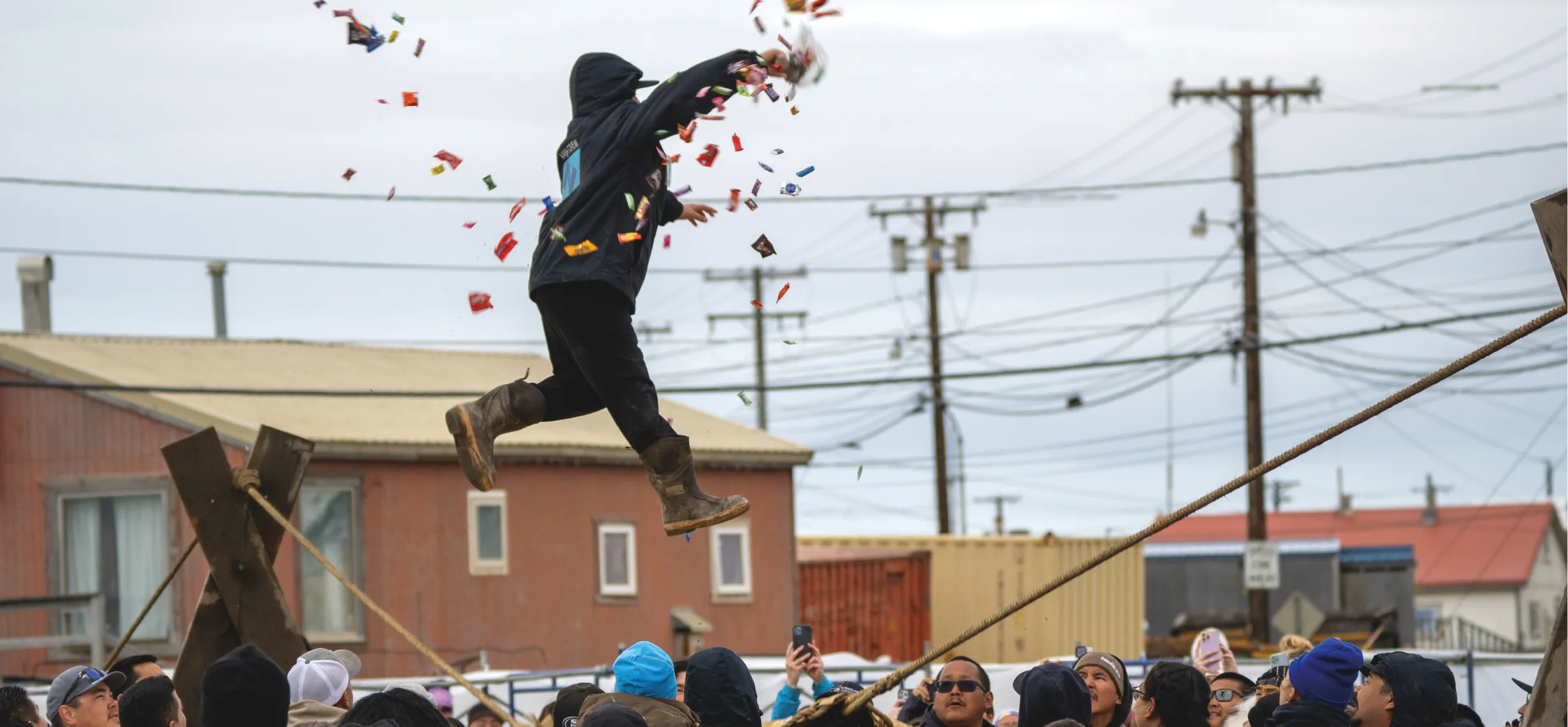 Person jumping in air with crowd watching and pieces of paper