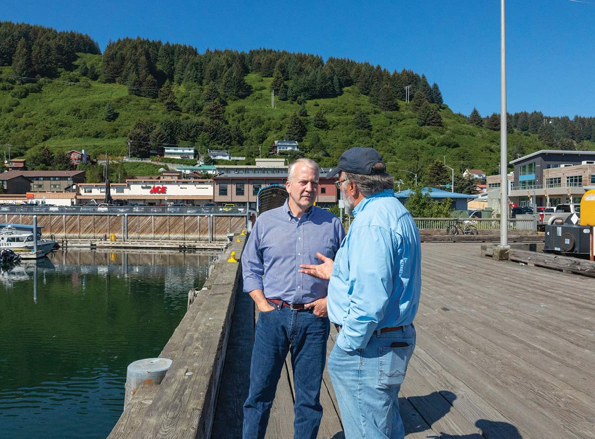 Senator Dan Sullivan discussing the Seafood Reciprocity Act of 2023 with an Alaskan fisherman in Kodiak on August 17, 2023 on a clear, bright sunny day out on a dock area