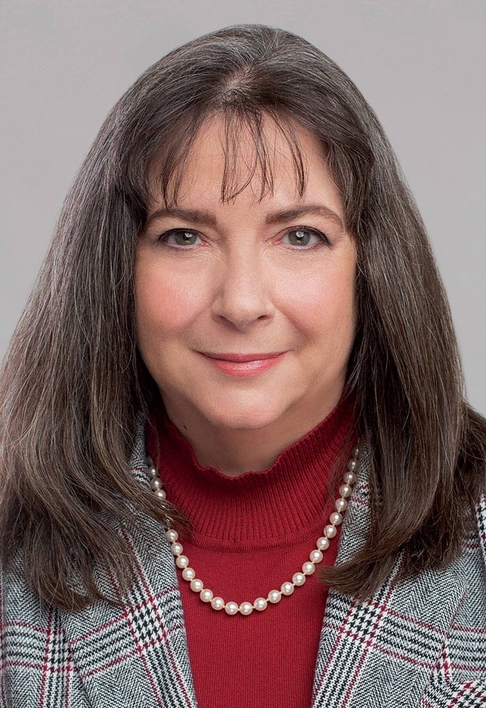 Portrait headshot photograph of Shelley Ebenal grinning