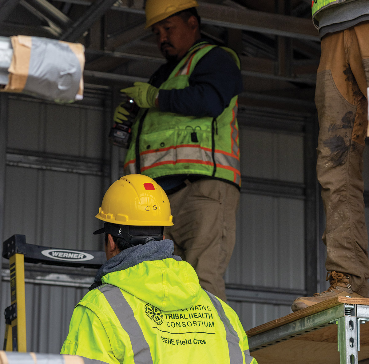 two construction workers in hard hats and yellow vests