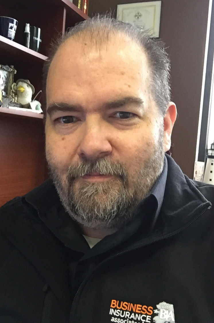 Chris' headshot, wearing a black polo and fleece