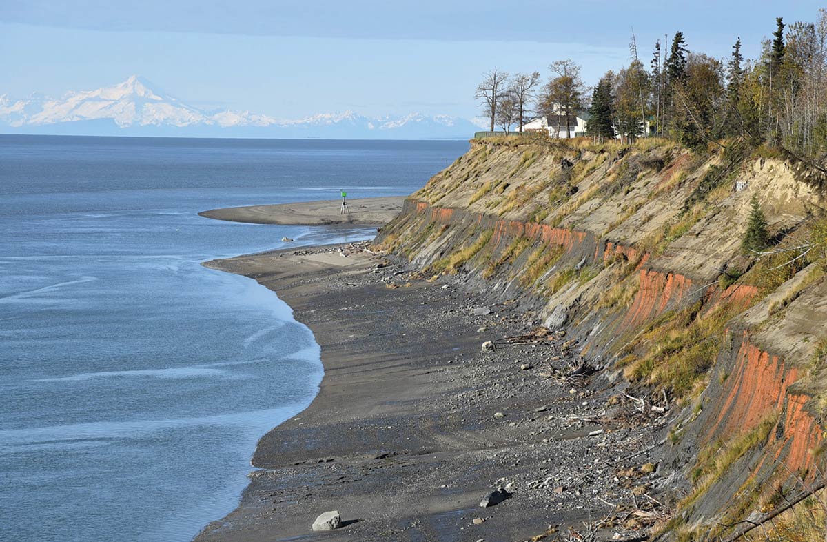 Aerial landscape photograph perspective of the eroding Kenai River Bluffs area in Kenai, Alaska during the day