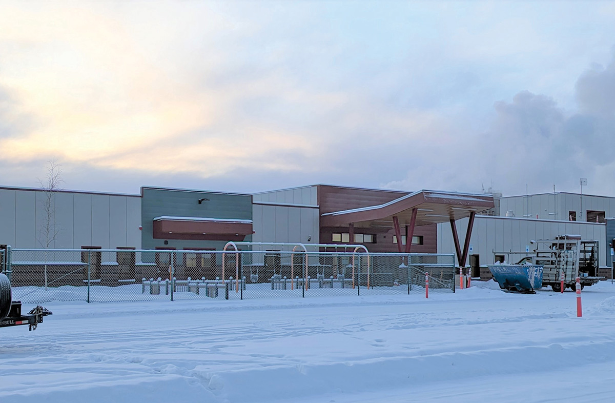 Aerial landscape photograph perspective of a new child development center facility at Fort Wainwright in Fairbanks Alaska during a cold day as fresh powder snow is layered on the ground