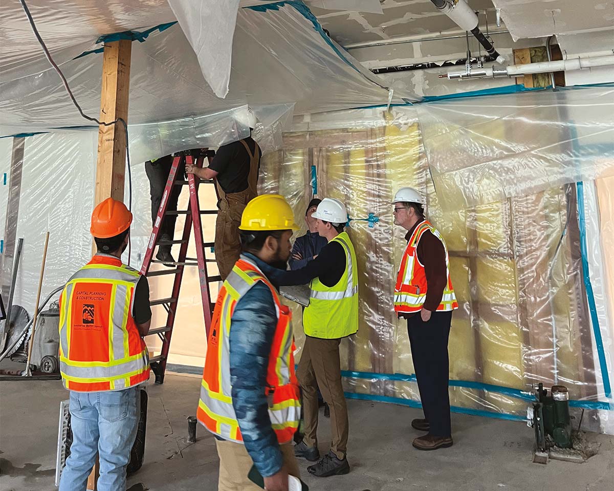 engineers in vests and hard hats inspecting a building