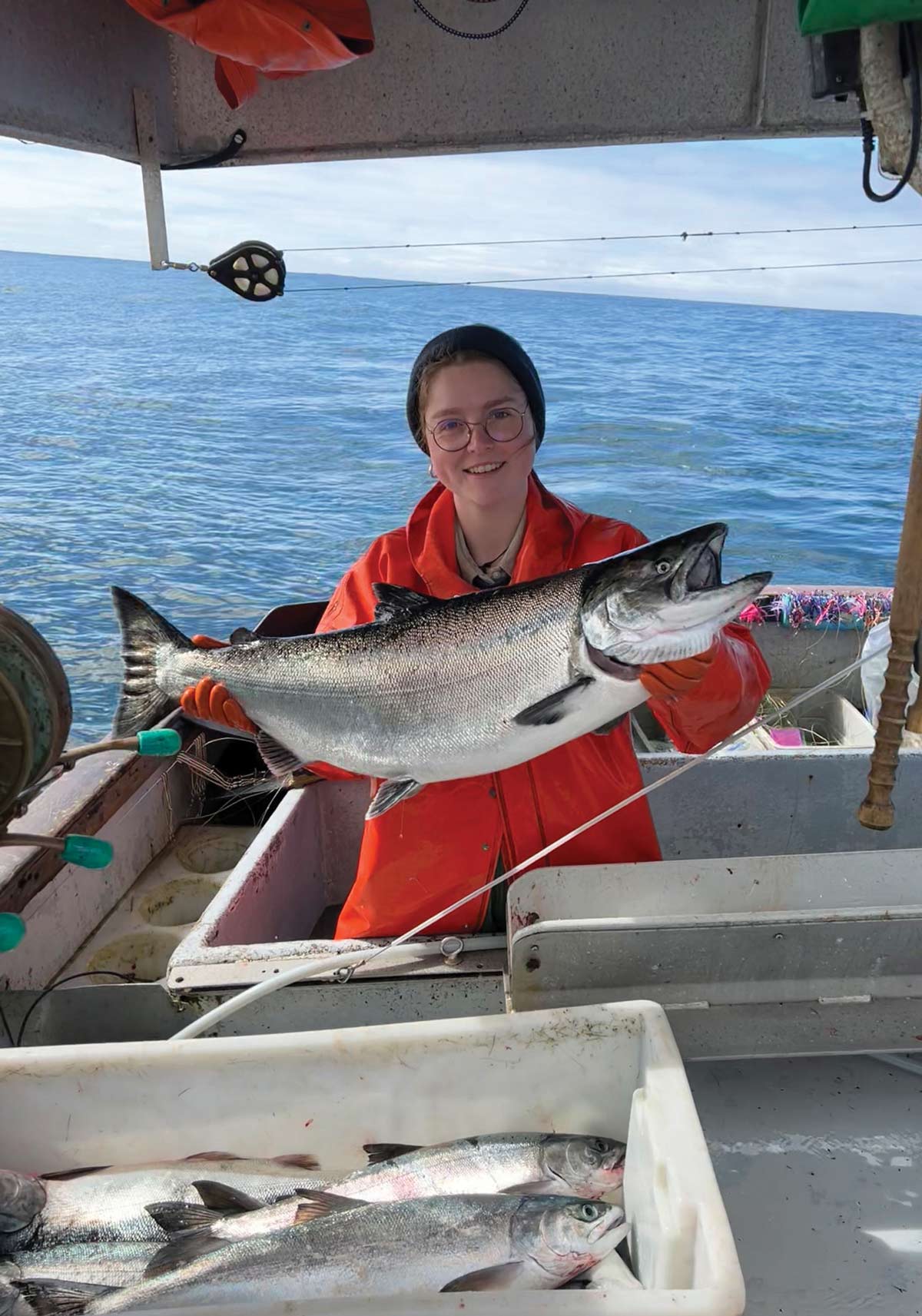 Alice Tirard holding a king salmon during her crew training placement