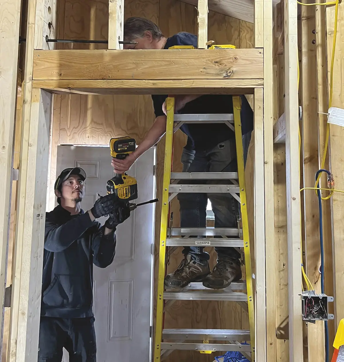 Point Lay resident Sonny Henry and TNHA plumber Jim Ladd work together to route indoor utilities.