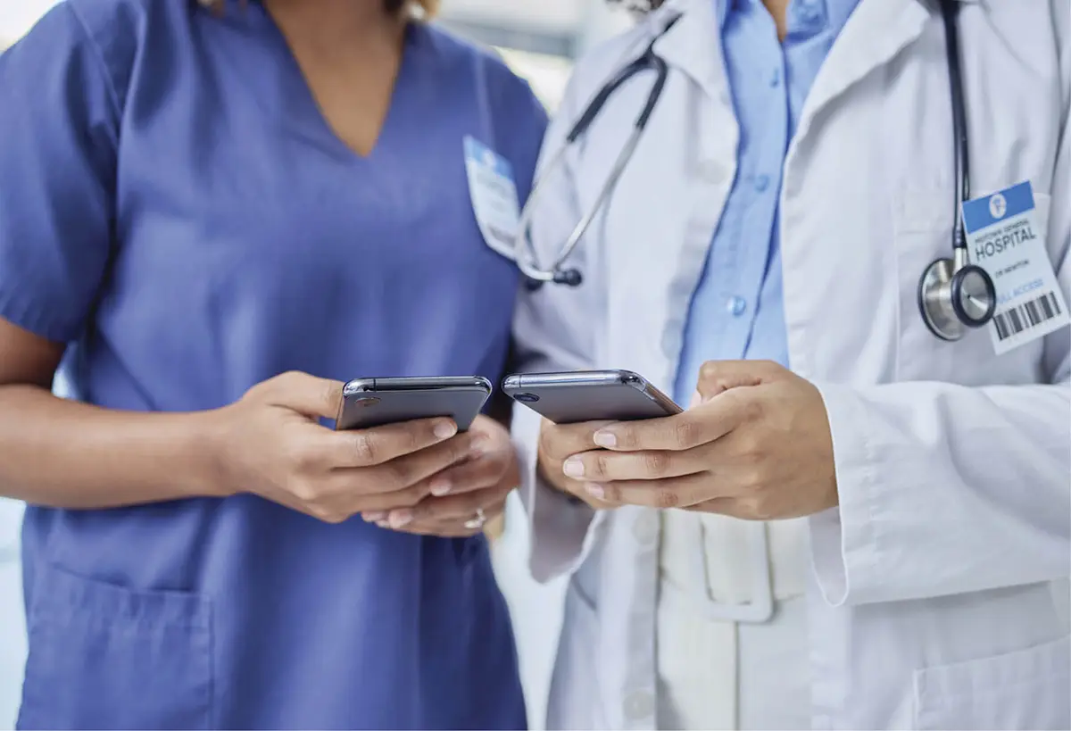 a nurse and doctor hold their phones up next to each other