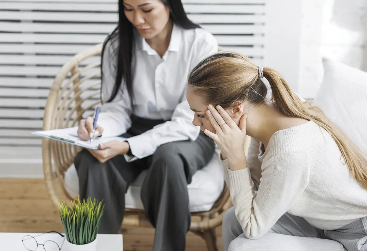 a distressed patient relays information to her doctor who is taking notes