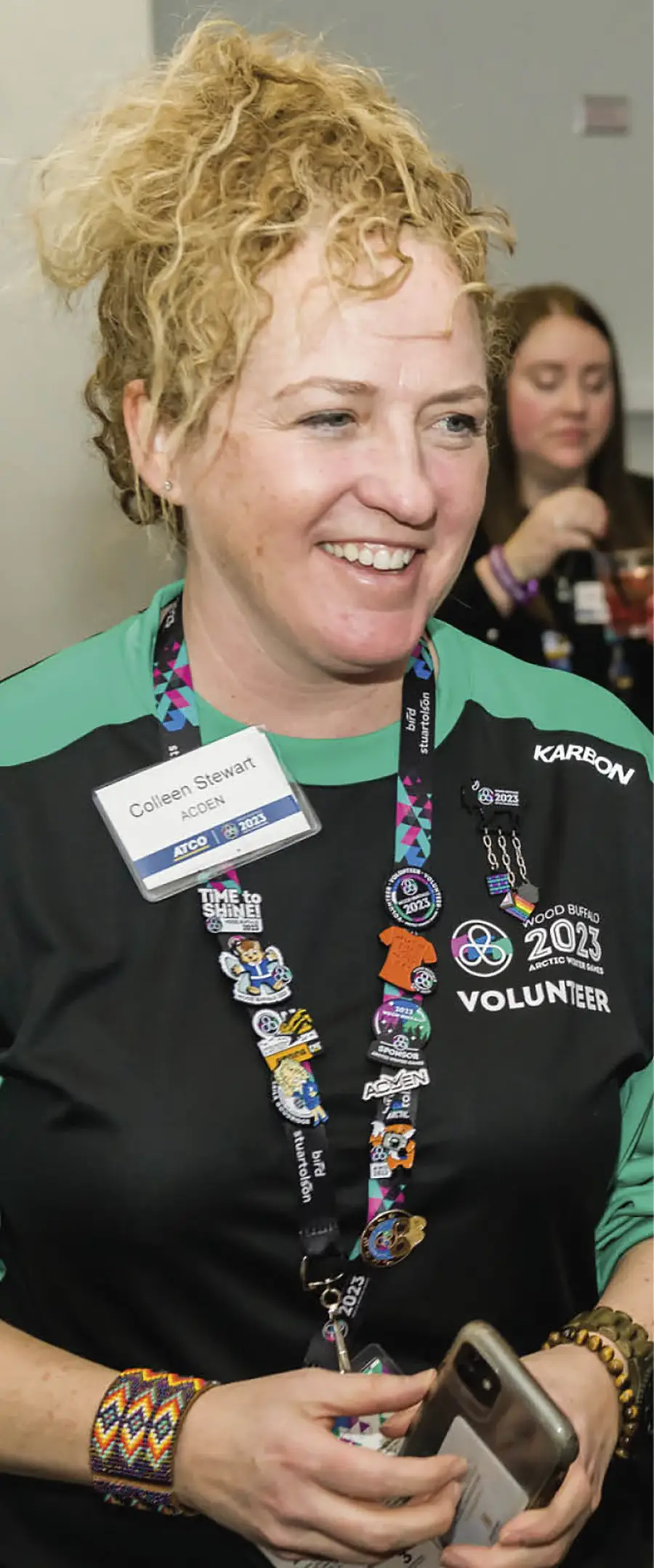 volunteer showing off all the pins she has collected on her lanyard