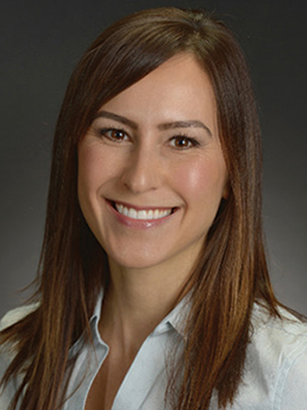 Headshot of a woman with long dark hair, wearing a white shirt