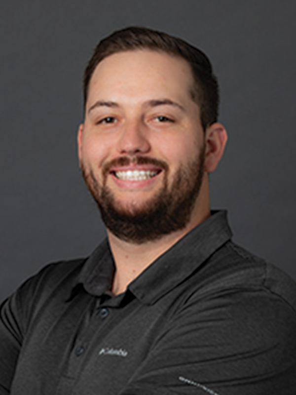 Headshot of a man wearing a black polo