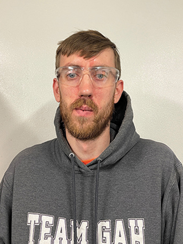 Headshot of a man wearing eye protection and a gray sweatshirt