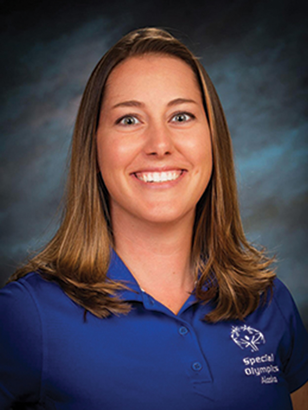 Headshot of a woman with short brown hair, wearing a blue polo shirt