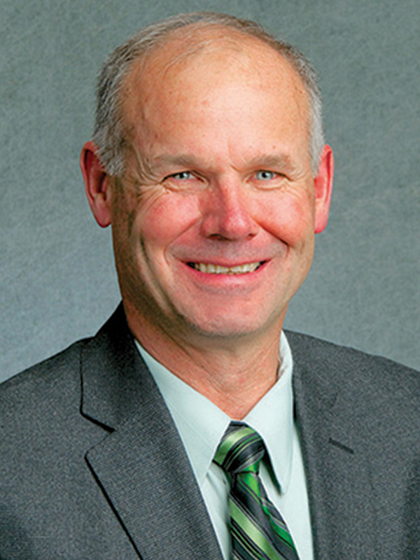 Headshot of a man wearing a suit and tie