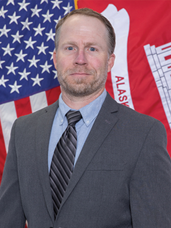 Headshot of a man wearing a suit and tie