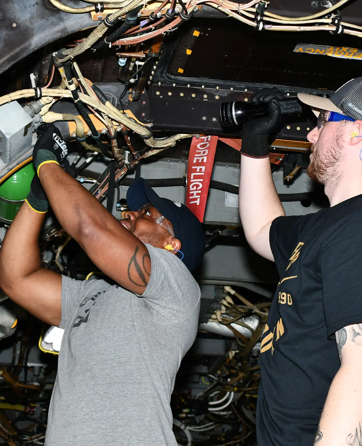inside the V-22 Osprey, as US Marine Corps Sergeant Darehle Perry (left) and a US Coast Guard veteran Joseph Cooper, inspect wiring