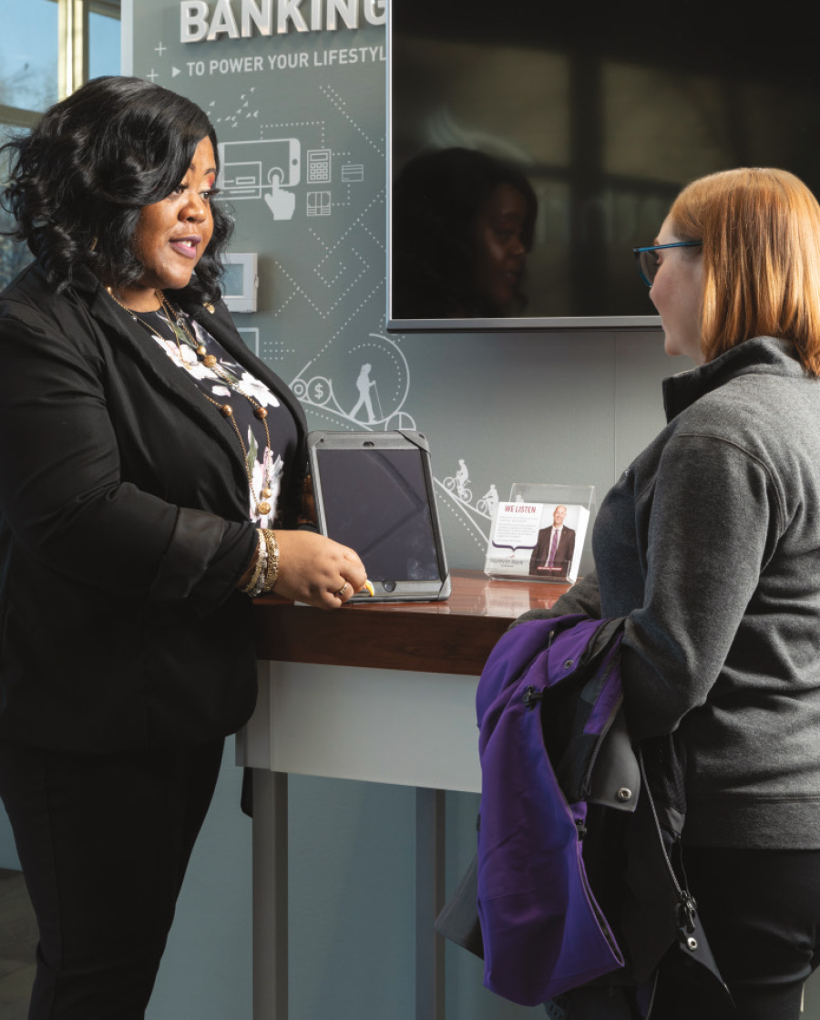 bank associate showing customer a tablet screen