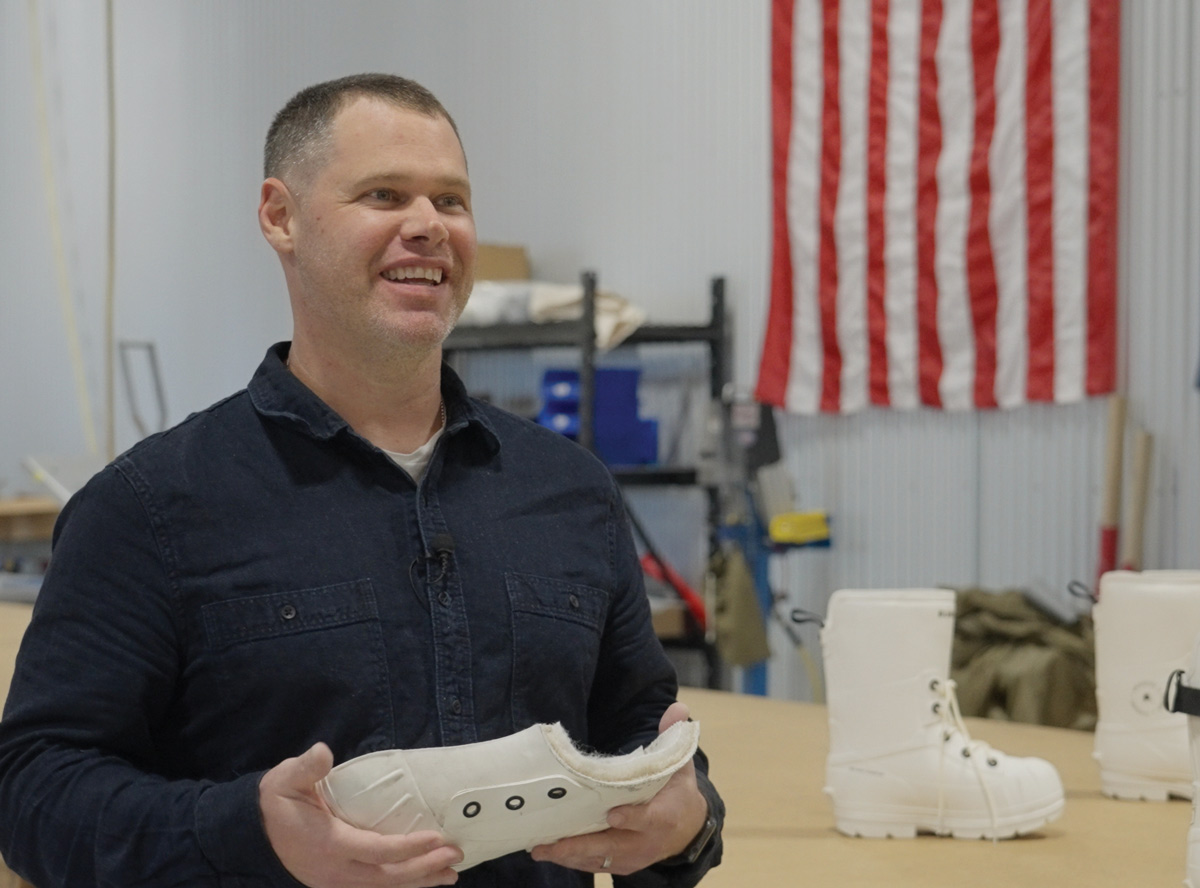 Mark Britton smiling and holding a bunny boot