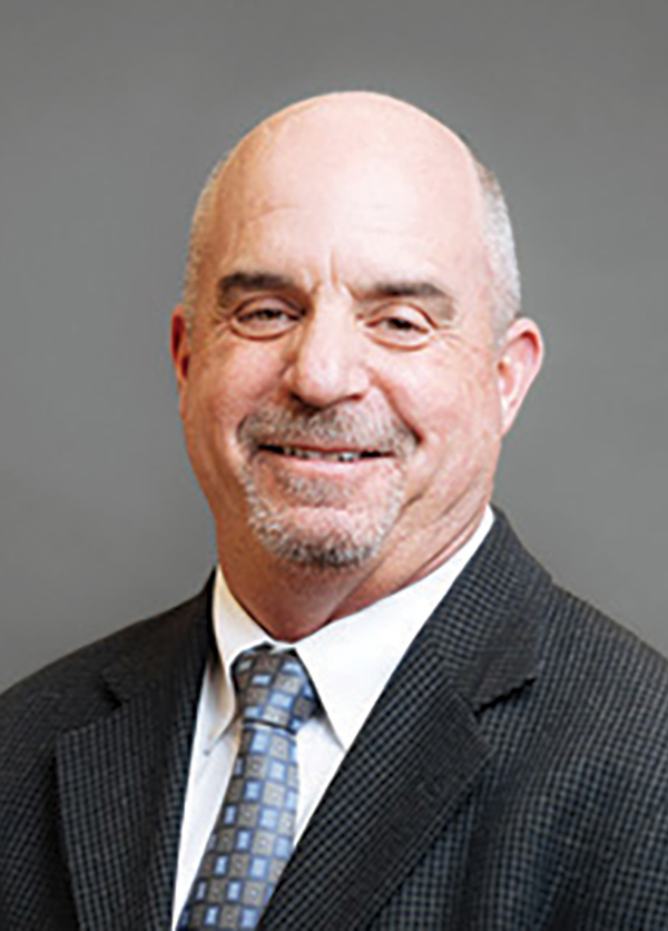 Portrait headshot photo of Doug Karet smiling