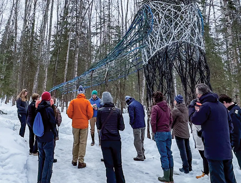attendees dressed in cold weather clothing stand in the Alaska Botanical Garden for the launch of John Messick's Compass Lines in 2023