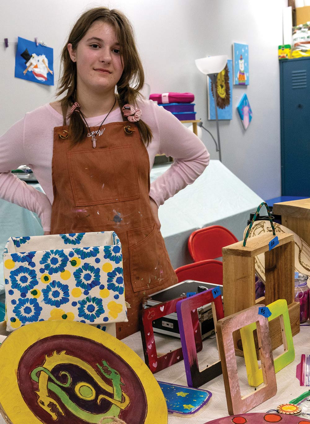 young girl standing at a booth where woodcraft is being sold