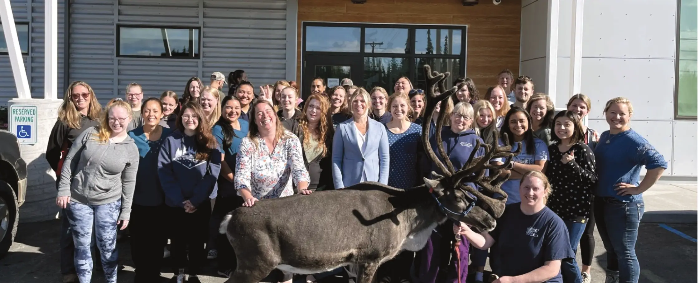 group photo of animal hospital workers and reindeer
