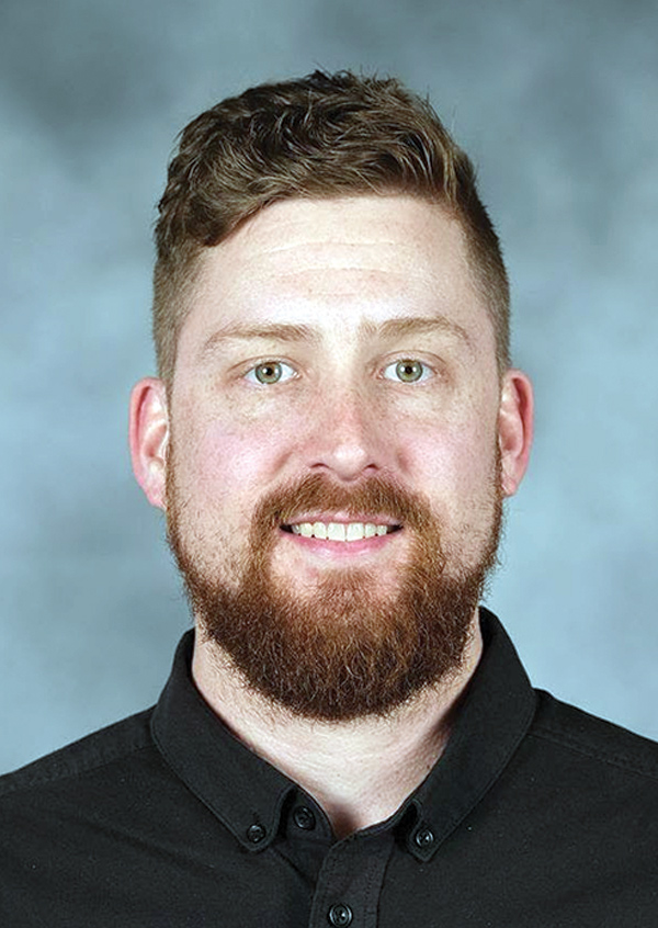 Portrait headshot photo of Sam Grubitz smiling