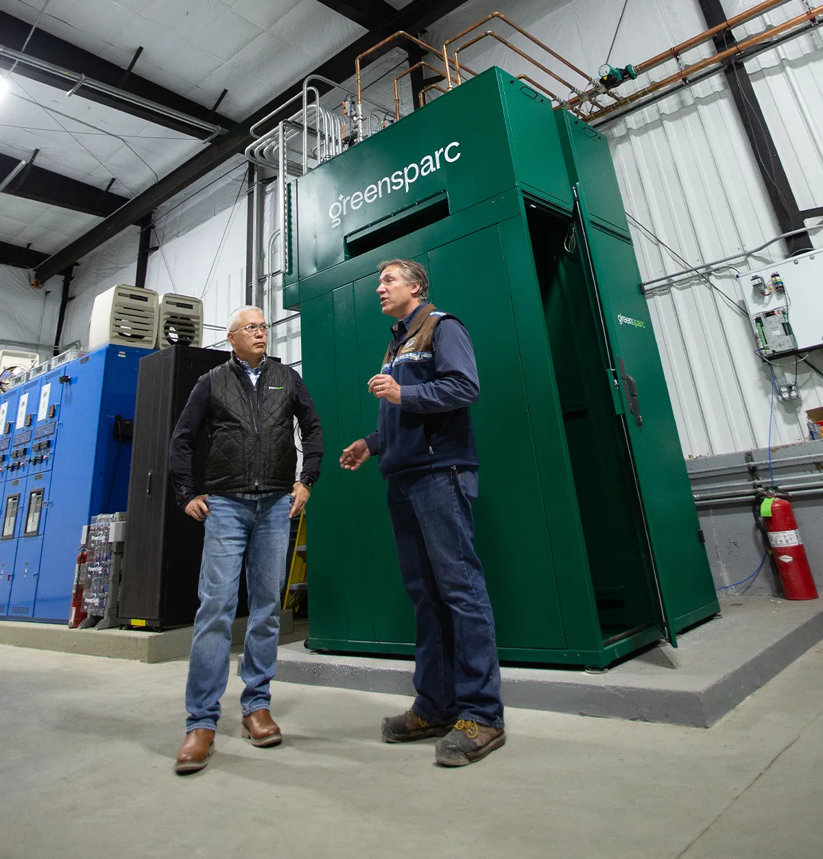 two men standing in front of Greensparc cabinets