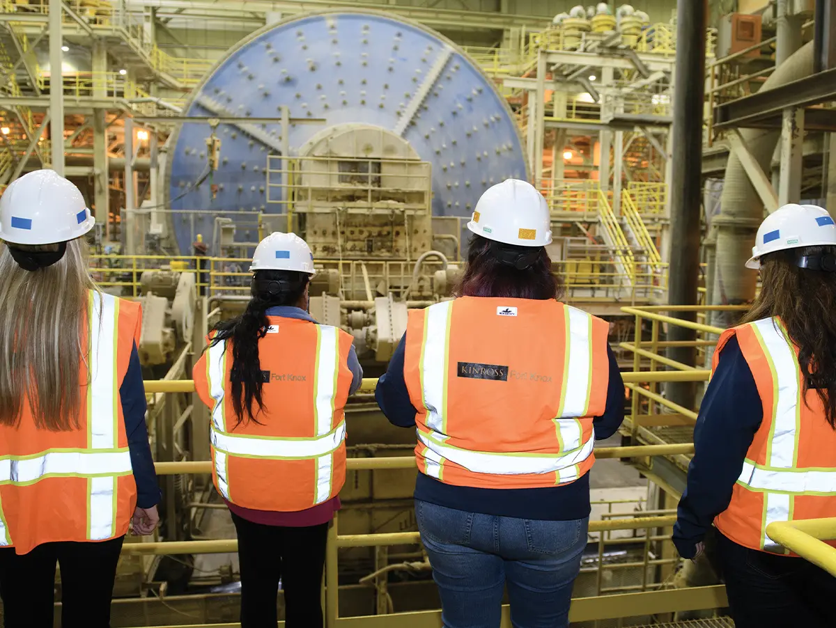 back view of four women wearing safety vests