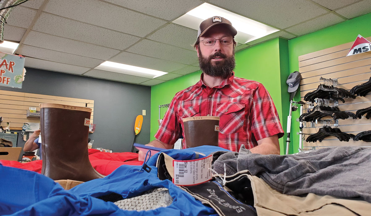 A man with a beard in a store, observing the merchandise displayed around him